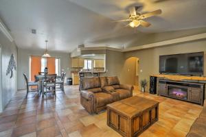 a living room with a couch and a tv and a table at Lake Havasu Getaway with Patio - Hike, Swim, and Golf! in Lake Havasu City