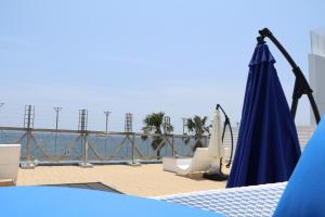 un paraguas azul y algunas sillas y un cuerpo de agua en Mykonos Resort Miura / Vacation STAY 62210, en Yokosuka 2 fotos más