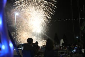 a group of people sitting at tables watching fireworks at Mykonos Resort Miura / Vacation STAY 62180 in Yokosuka