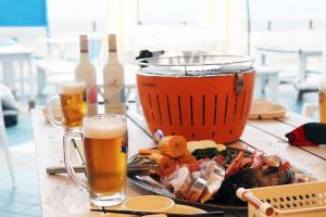 a table with a plate of food and two glasses of beer at Mykonos Resort Miura / Vacation STAY 62180 in Yokosuka