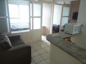 sala de estar con sofá y microondas en la barra en Apartamento 308, Marina, Centro - Torres - RS, en Torres