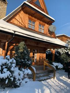 Cabaña de madera con nieve en el porche en Domek Krupówki z widokiem na Giewont, en Zakopane