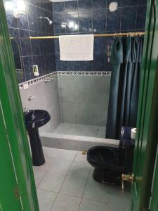y baño con ducha, aseo y lavamanos. en CasKaffeSu Hotel and Restaurant Mindo, en Mindo