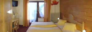 a bedroom with a bed and a window at Alpenhof Schwaiger - Hotel Garni in Mühlbach am Hochkönig