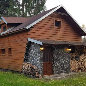 a log cabin with a door and a stone wall at Chata pod skalou in Valaská