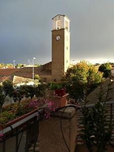 une tour d'horloge au sommet d'un bâtiment avec des plantes dans l'établissement Casa Rural Los Pinos, à Valmuel