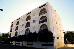 - un bâtiment blanc avec des balcons sur le côté dans l'établissement AlgarveInn, à Altura