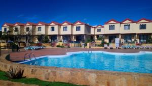 a resort with a large swimming pool in front of a building at fuerte blue in Costa Calma