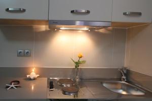 a kitchen with a sink and a vase with a flower at Chios Xenia Studios & Apartments in Paralia Agias Foteinis +84 photos