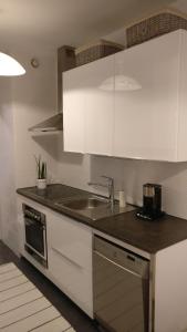 uma cozinha com armários brancos e um lavatório em 4 km to the Jyväskylä city center afoot, cute apartment with free parking em Jyväskylä