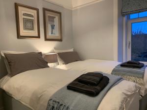 two beds in a bedroom with two towels on them at Cliffside in Lossiemouth