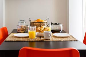 una mesa con una cesta de pan y zumo de naranja en Home Sweet Home 3 en Nafplio