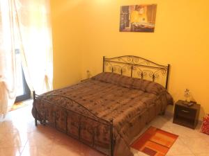 um quarto com uma cama numa parede amarela em L'APPARTAMENTINO DIAMOND em Frosinone