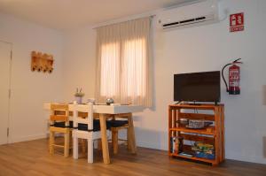 a living room with a table and a television at Apartamento La Guinda in Consuegra