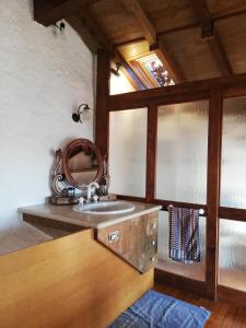 a bathroom with a sink and a mirror at Romantica casetta nel verde con vista sul lago in Belgirate