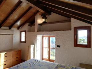 a bedroom with a bed and a window at Romantica casetta nel verde con vista sul lago in Belgirate