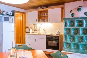 a kitchen with white cabinets and a blue oven at Hütte Gerlitzen RegioJet Hotels&Cottages in Bodensdorf +46 photos