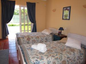 a bedroom with two beds with towels on them at Villa Tenazinha III in Albufeira