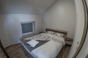 a bedroom with a large bed and a mirror at Apartma Marička in Križe