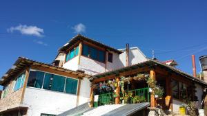 a house with a green gate in front of it at HOSPEDAJE BELLA VISTA MONGUI in Monguí