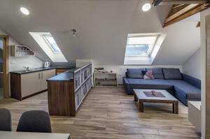a living room with a blue couch and a kitchen at Apartma Marička in Križe