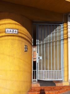 a door to a yellow building with a gate at Resimed in Antofagasta