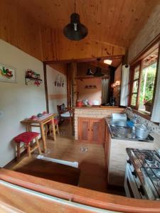 uma cozinha com um fogão e uma mesa em Chale Raio De Luz em Visconde de Mauá