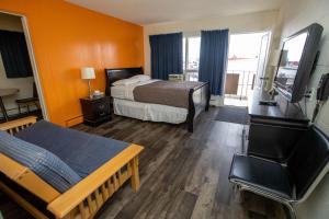 a hotel room with a bed and a television at Camrose Motel in Camrose