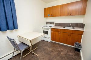 a small kitchen with a table and a sink at Camrose Motel in Camrose