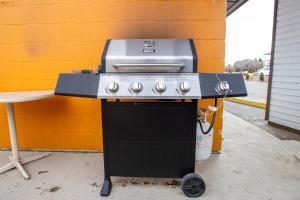 un grill assis à côté d'un mur orange dans l'établissement Camrose Motel, à Camrose