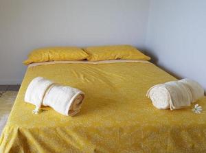 a yellow bed with two towels on top of it at Le Tiki Rouge in Punaauia +2 photos