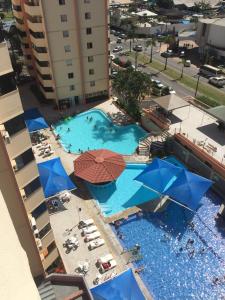 - une vue sur la piscine bordée de parasols et de chaises dans l'établissement Parque das Águas Quentes, à Caldas Novas