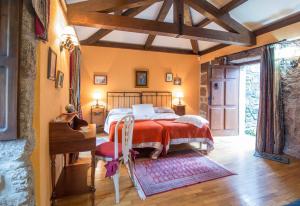 Pazo Da Fraga في Albeos: غرفة نوم بسرير وبطانية حمراء