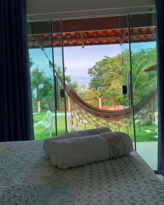a bed with a hammock in a room with a window at Pousada Yvanna in Pirenópolis