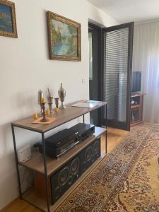 a living room with a table with a tv at Apartman 3S Pale Jahorina in Pale