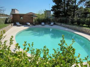 a large blue swimming pool with chairs in a yard at El Montenegrino in Tandil