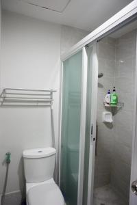 uma casa de banho com um WC e uma cabina de duche em vidro. em Comfy condo unit 5mins from Mactan Airport+Netflix em Mactan