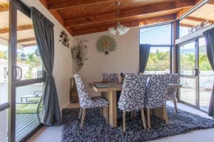 een eetkamer met een tafel en stoelen bij Peacock Lodge in Ngunguru in Ngunguru