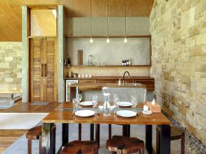 eine Küche mit einem Holztisch und einem Waschbecken in der Unterkunft Batatu Villas in Kuta Lombok