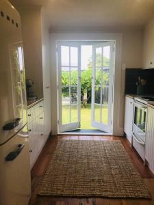 a kitchen with an open door to a yard at Bryce Cottage in Cambridge