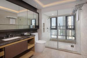 a bathroom with a shower and a toilet and a sink at Somerset Grandview Shenzhen in Shenzhen