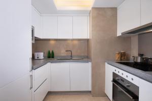 a kitchen with white cabinets and a sink at Somerset Grandview Shenzhen in Shenzhen