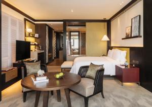 um quarto de hotel com uma cama e uma mesa em Rosewood Phnom Penh em Phnom Penh