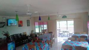 a room with a group of tables and chairs at Transit Motel in Mulifanua