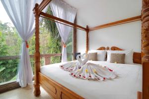 a bedroom with a bed with a swan decoration on it at The Bejalin Eco Retreat in Plaga +68 photos