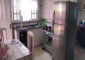 a kitchen with a stainless steel refrigerator and a stove at Peruibe Centro e Mar 940 in Peruíbe