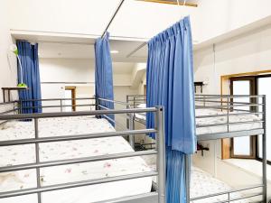 two bunk beds in a hospital room with blue curtains at Akasakano-sato(Premium) in Tokyo