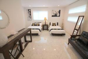 a large room with two beds and a couch at Casa de nicki 恩納村 in Onna