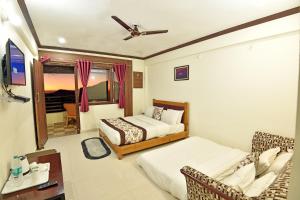 a hotel room with two beds and a tv at Green Roof Hotel in Nainital