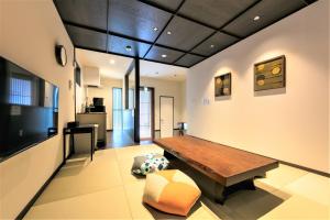 a living room with a wooden table and a kitchen at MUSUBI HOTEL MACHIYA Naraya-machi 1 in Fukuoka